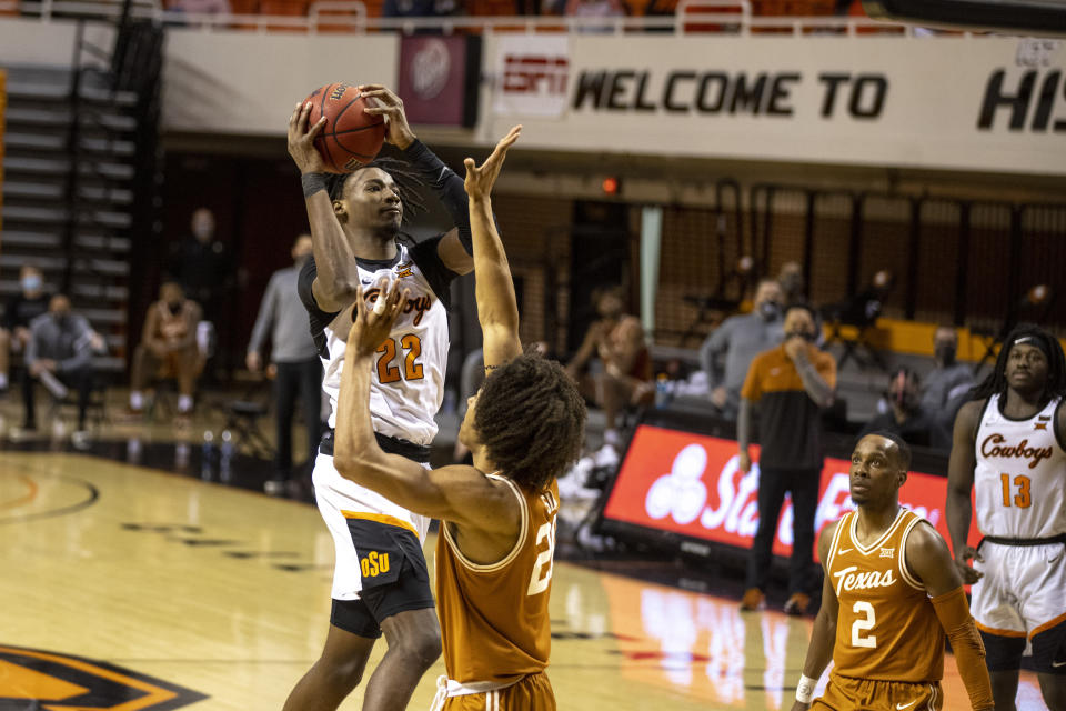 Oklahoma State forward Kalib Boone (22) shoots the ball over Texas forward Jericho Sims (20) during the first overtime of the NCAA college basketball game in Stillwater, Okla., Saturday, Feb. 6, 2021. (AP Photo/Mitch Alcala)