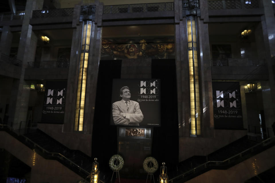 A poster with the image of Mexican crooner Jose Jose is displayed at the Palace of Fine Arts during a homage, in Mexico City, Wednesday, Oct. 9, 2019. Jose Jose died Sept. 28 in South Florida. His body was cremated in Miami and it was agreed after a dispute among relatives that half the ashes would remain there and the other half would be brought to Mexico. (AP Photo/Fernando Llano)