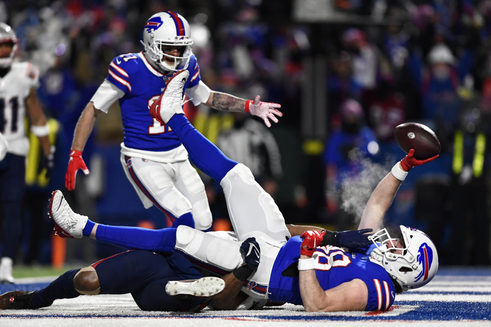 Buffalo Bills tight end Dawson Knox (88) scores a touchdown against New England Patriots safety Adrian Phillips, below, during the first half of an NFL wild-card playoff football game, Saturday, Jan. 15, 2022, in Orchard Park, N.Y. (AP Photo/Adrian Kraus)