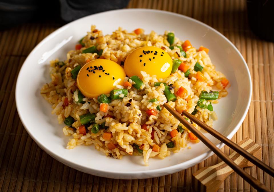 a plate of tamago gohan with two egg yolks on top