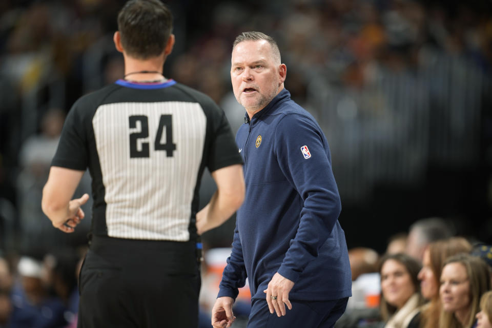Denver Nuggets head coach Michael Malone, right, argues for a call with referee Kevin Scott in the first half of an NBA basketball game against the Golden State Warriors on Wednesday, Nov. 8, 2023, in Denver. (AP Photo/David Zalubowski)