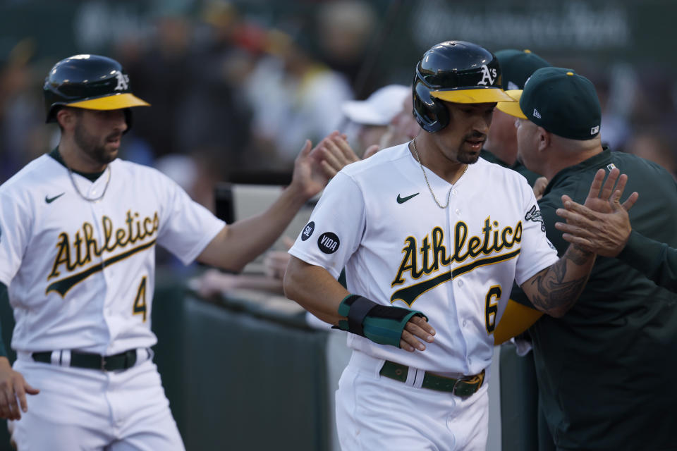 Oakland Athletics' Jace Peterson (6) and Kevin Smith (4) are congratulated by teammates after scoring on a double by Shea Langeliers during the fifth inning of a baseball game against the Tampa Bay Rays in Oakland, Calif., Monday, June 12, 2023. (AP Photo/Jed Jacobsohn)