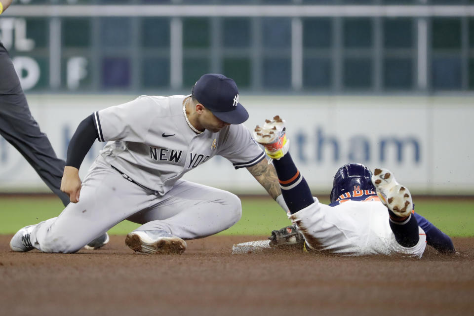 New York Yankees second baseman Gleyber Torres, left, makes the tag for the out as Houston Astros Mauricio Dubon right is caught stealing during the fifth inning of a baseball game, Sunday, Sept. 3, 2023, in Houston. (AP Photo/Michael Wyke)