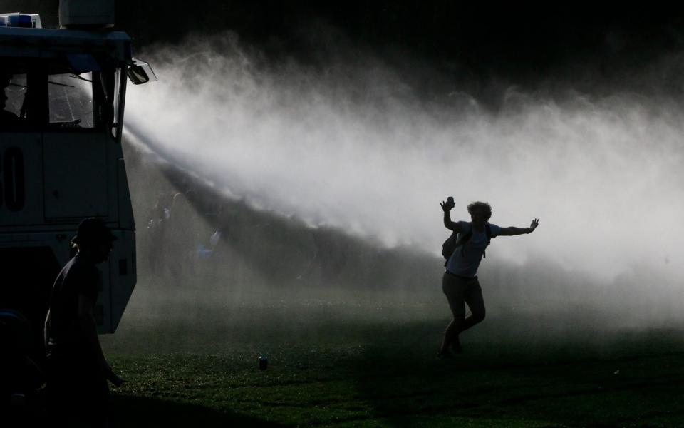 olice use water cannons to disperse people as they take part in fake festival called 'La Boum' organized by an anonymous group of people on Facebook for an April Fool's joke  - STEPHANIE LECOCQ/EPA-EFE/Shutterstock 