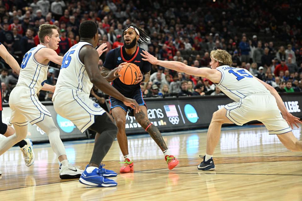 Duquesne guard Dae Dae Grant (3) is covered by Brigham Young during in the first half during the first round of the NCAA men's tournament at CHI Health Center Omaha.