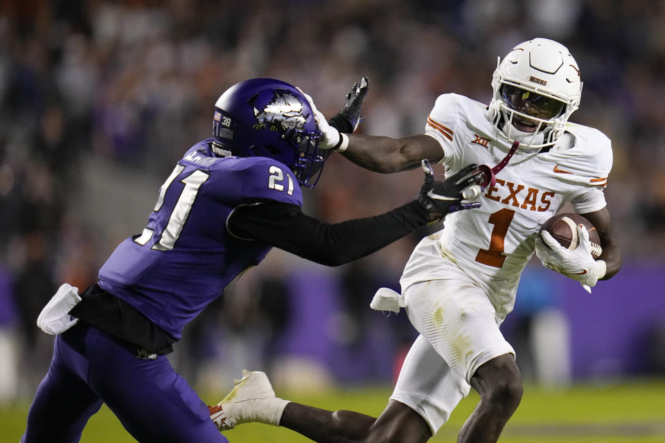Texas wide receiver Xavier Worthy (1) applies a stiff arm on TCU safety Bud Clark (21) during the first half of an NCAA college football game, Saturday, Nov. 11, 2023, in Fort Worth, Texas. (AP Photo/Julio Cortez)