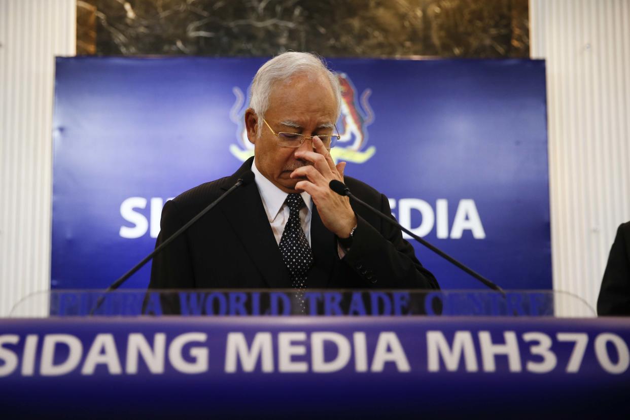 Malaysian Prime Minister Najib Razak, center, gestures before speaking at a special press conference announcing the findings for the ill fated flight MH370 in Kuala Lumpur, Malaysia, early Thursday, Aug. 6, 2015. Experts have confirmed that the debris found on Reunion Island last week was that of Malaysian Airlines flight 370 that went missing last year, Malaysia's prime minister said early Thursday. (AP Photo/Vincent Thian)