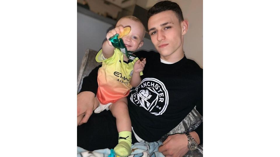 Phil Foden with his son wearing his medal