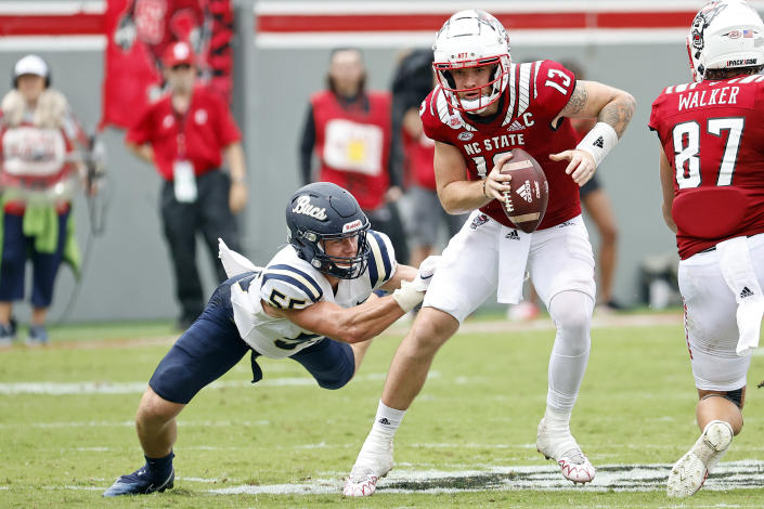 North Carolina State's Devin Leary (13) tries to break away from Charleston Southern's Nick Perry (55) during the first half of an NCAA college football game in Raleigh, N.C., Saturday, Sept. 10, 2022. (AP Photo/Karl B DeBlaker)