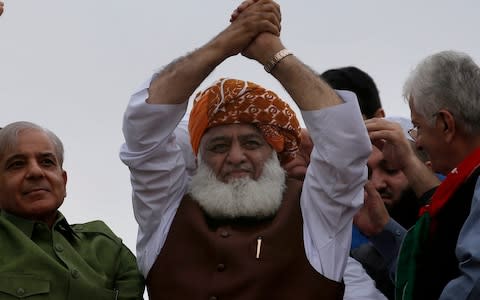 Maulana Fazlur Rehman waves to his supporters during the protest - Credit: AP Photo/Anjum Naveed