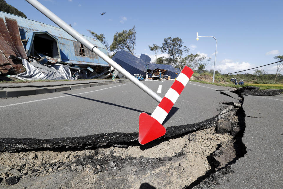 A cracked road and destroyed buildings are seen after an earthquake in Atsuma town, Hokkaido, northern Japan, Thursday, Sept. 6, 2018. Several people were reported missing in the nearby the town, where a massive landslide engulfed homes in an avalanche of soil, rocks and timber. (Masanori Takei/Kyodo News via AP)