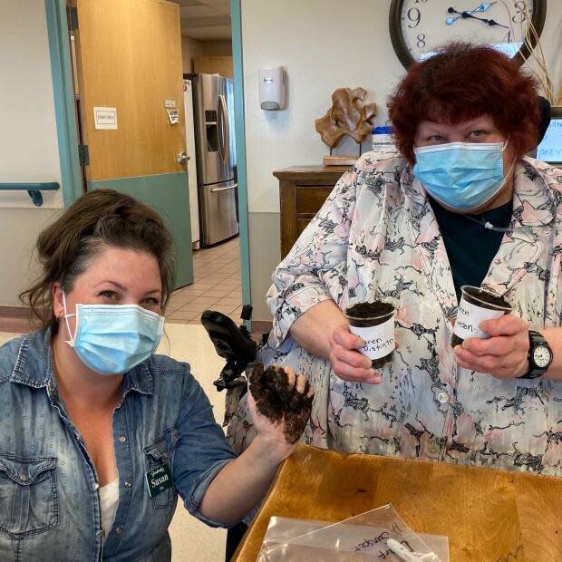 Nurse Susan Dyck preparing sunflower seedlings with a resident of Sherbrooke Community Centre.