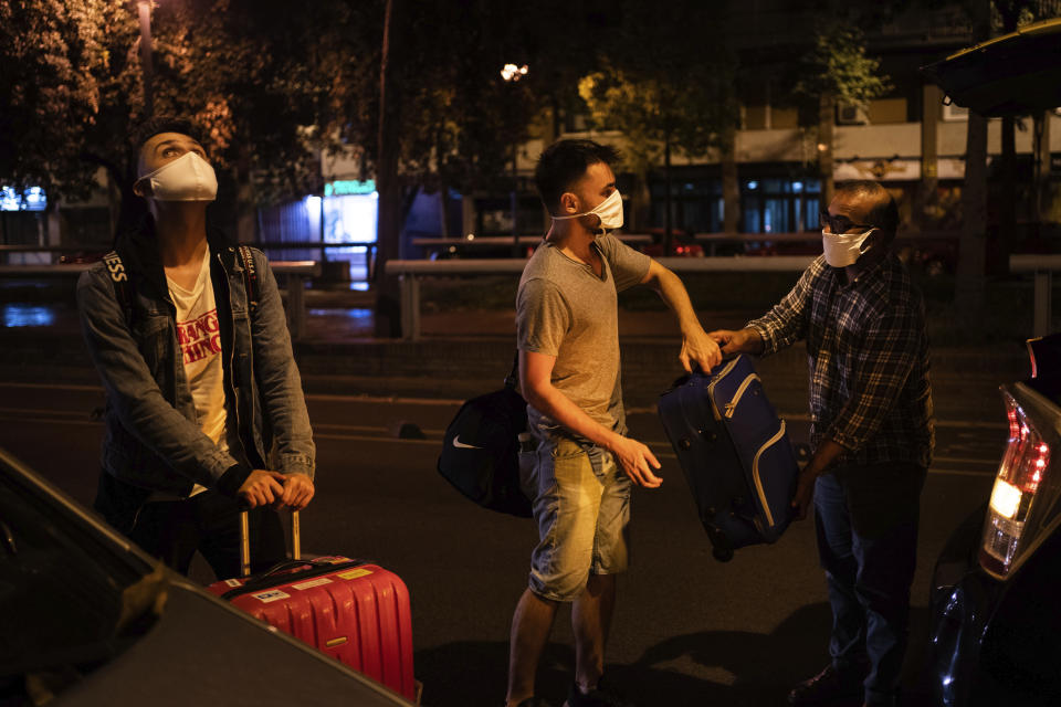 Piotr Grabarczyk, left, is helped by his boyfriend Kamil Pawlik, from Poland, after arriving in Barcelona, Spain, early Wednesday, July 29, 2020. Like them, many LGBT people are choosing to leave Poland amid rising homophobia promoted by President Andrzej Duda and other right-wing populist politicians in power. (AP Photo/Felipe Dana)