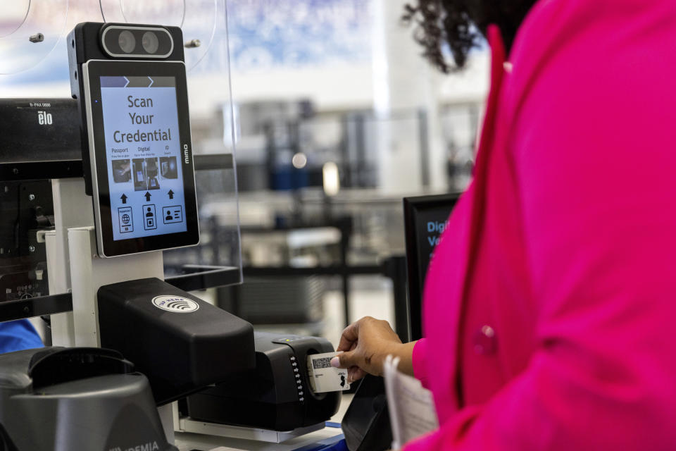 A person inserts an ID card while demonstrating the Transportation Security Administration's new facial recognition technology at a Baltimore-Washington International Thurgood Marshall Airport security checkpoint, Wednesday, April 26, 2023, in Glen Burnie, Md. (AP Photo/Julia Nikhinson)