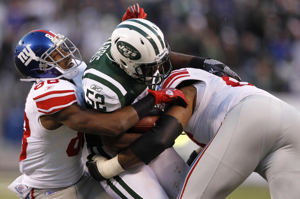 David Harris #52 of the New York Jets is tackled by Hakeem Nicks #88 and Kareem McKenzie #67 of the New York Giants after intercepting a pass during the second half of a game at MetLife Stadium on December 24, 2011 in East Rutherford. New Jersey. (Photo by Rich Schultz /Getty Images)