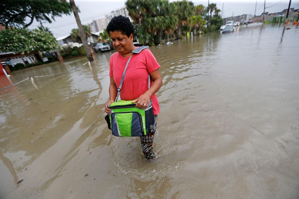 <p>Esther Martens walk through a flooded roadway to get to her car in the West End section of New Orleans, La., on Wednesday, June 21, 2017. Tropical Storm Cindy formed Tuesday in the Gulf of Mexico, hovering south of Louisiana as it churned tides and spun bands of heavy, potentially flooding rain onto the central and eastern Gulf Coast. (Photo: Gerald Herbert/AP) </p>