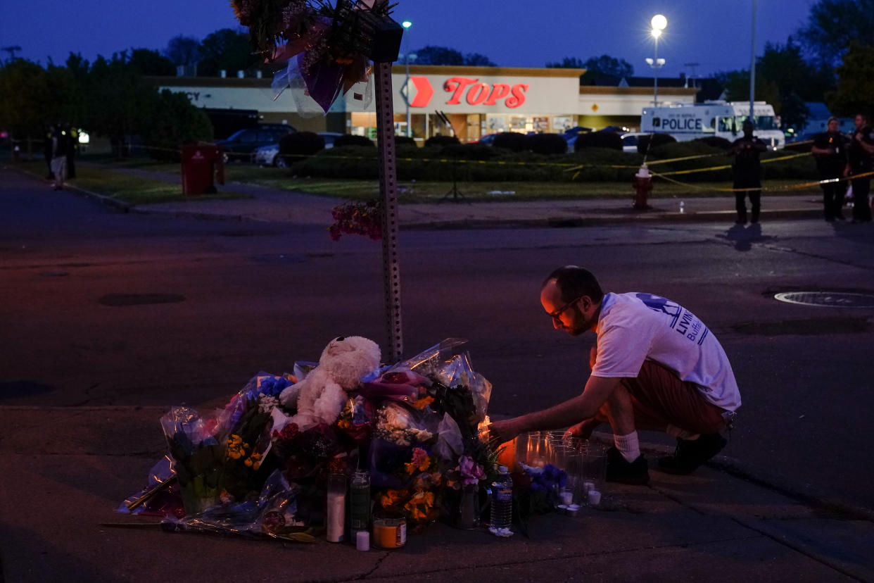 A person pays his respects outside the scene of the Tops market shooting in Buffalo.