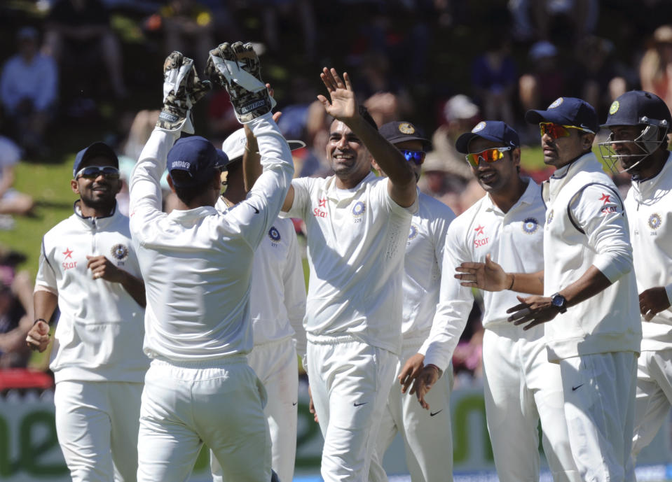 India’s Zaheer Khan, center, high fives with MS Dhoni after he took the catch off Zaheer's bowling to dismiss New Zealand’s Hamish Rutherford for 35 on the third day of the second cricket test at Basin Reserve in Wellington, New Zealand, Sunday, Feb. 16, 2014. (AP Photo/SNPA, Ross Setford) NEW ZEALAND OUT