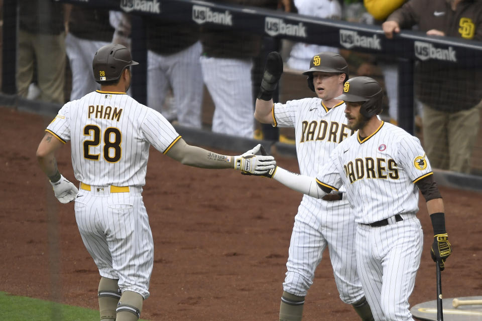 San Diego Padres' Tommy Pham (28) is congratulated by Jake Cronenworth, center, and Austin Nola, right, after hitting a two-run home run during the first inning of a baseball game against the St. Louis Cardinals, Saturday, May 15, 2021, in San Diego. (AP Photo/Denis Poroy)