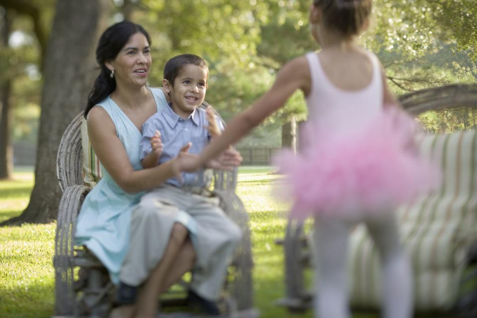 4th of july activities mom and son sitting in a chair clapping for dancing daughter