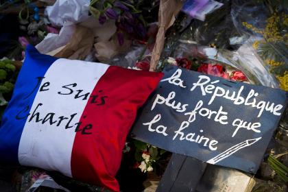 A cushion reading “Je suis Charlie (I am Charlie)” and placard reading “The Republic, stronger than hate” sit outside the French satirical weekly Charlie Hebdo in Paris on Feb. 7, 2015, saluting victims of the January attacks there. (AFP Photo/Joel Saget)