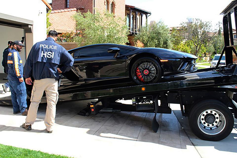 This photo provided by U.S. Immigration and Customs Enforcement shows special agents with HSI Los Angeles's El Camino Real Financial Crimes Task Force seize a Lamborghini from an Orange County businessman on Thursday, April 6, 2021, in Irvine, Calif. Mustafa Qadiri, 38, of Irvine, was named in a federal grand jury indictment and has pleaded not guilty to charges he obtained $5 million in federal coronavirus-relief loans for phony businesses and then used the money for lavish vacations and to buy a Ferrari, Bentley and Lamborghini, prosecutors said Monday, May 10.