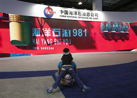 A boy looks at a promotional video about Chinese oil rig Haiyang Shi You 981 at a booth of China's state-run oil company CNOOC during China Beijing International High-Tech Expo in Beijing, May 16, 2014. REUTERS/Kim Kyung-Hoon