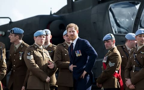 Prince Harry with the Army Air Corps graduates in front of an Apache helicopter - Credit: Heathcliff O'Malley