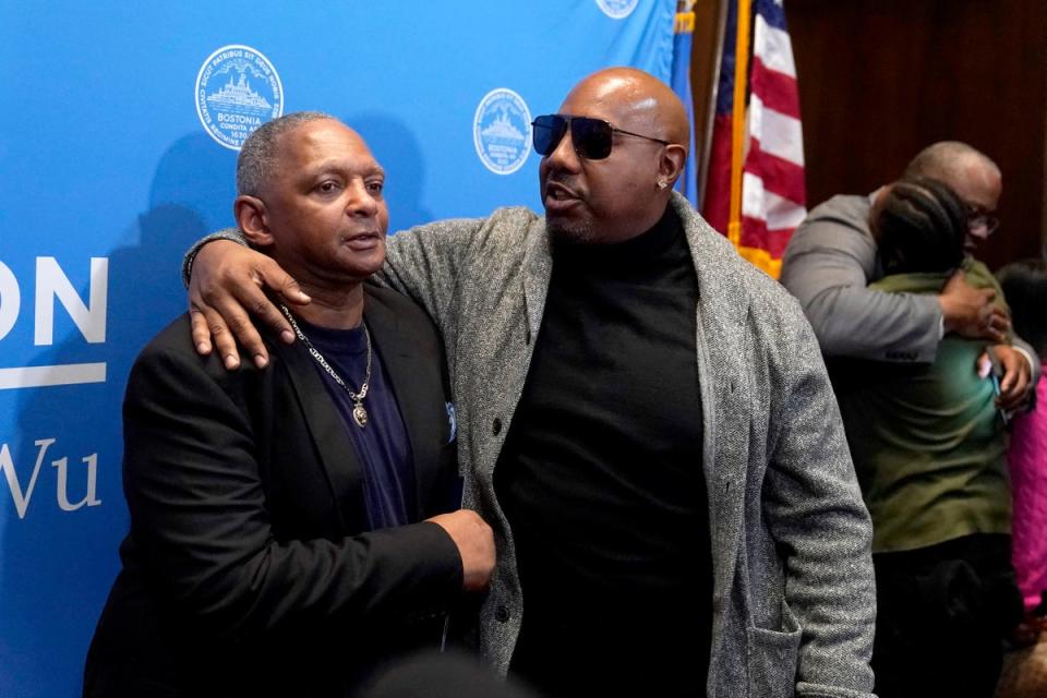 Alan Swanson, left, is embraced by Joseph Bennett, nephew of Willie Bennett, center, following a news conference Wednesday, Dec. 20, 2023, in Boston (AP)