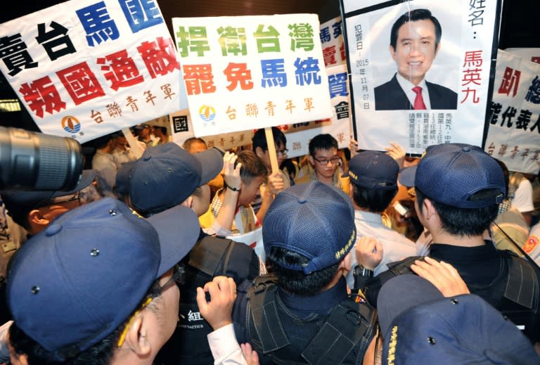 Pro-independence activists from the Taiwan Solidarity Union (TSU), holding a portrait of President Ma Ying-jeou, clash with police at Taoyuan airport, on November 8, 2015