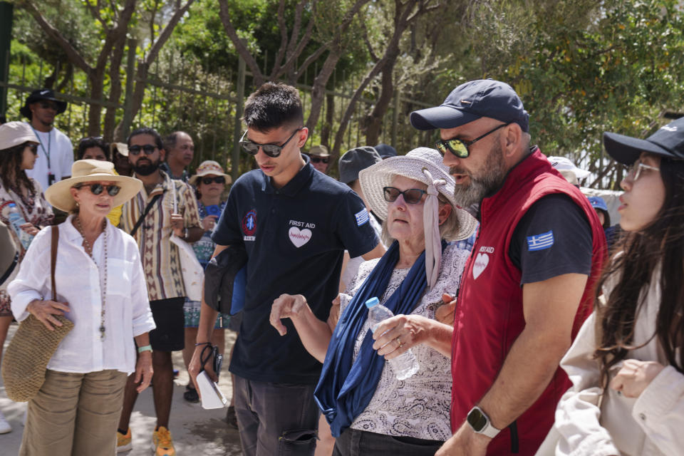 A tourist is carried by First Aid personnel from ancient Acropolis site, in central Athens, Wednesday, June 12, 2024. The ancient Acropolis site was closed to the public for five hours due to a heat wave that pushed temperatures to 39 degrees Celsius (102 Fahrenheit) in the capital and even higher in parts of central Greece. (AP Photo/Petros Giannakouris)