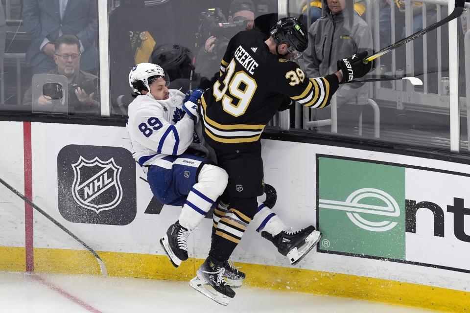 Boston Bruins' Morgan Geekie (39) checks Toronto Maple Leafs' Nicholas Robertson (89) during the third period in Game 1 of an NHL hockey Stanley Cup first-round playoff series Saturday, April 20, 2024, in Boston. (AP Photo/Michael Dwyer)