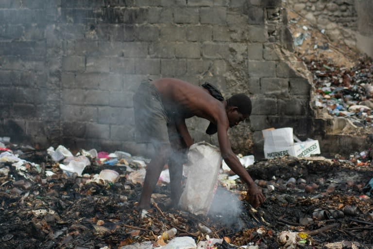 Un hombre busca entre los restos de basura en Puerto Príncipe el 13 de abril de 2024 (Clarens SIFFROY)