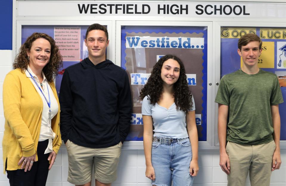 (Left to right) Westfield High School Principal Mary Asfendis congratulates Cooper DelGandio, Audrey Jones and Matthew Christian, who earned perfect scores on recent ACT and SAT subject tests.