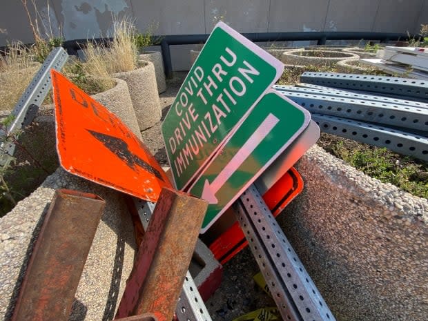 Signs for COVID-19 immunization clinics lie unused on the ground at Evraz Place in Regina, on Sept. 9, 2021.   (Matthew Howard/CBC - image credit)