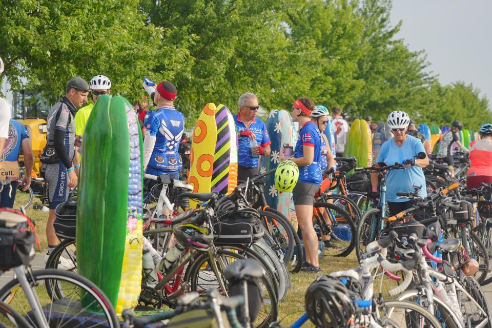 Bikers rest on corn sculptures as riders stop in Altoona on Day 5 of RAGBRAI 50 on Thursday, July 27, 2023.