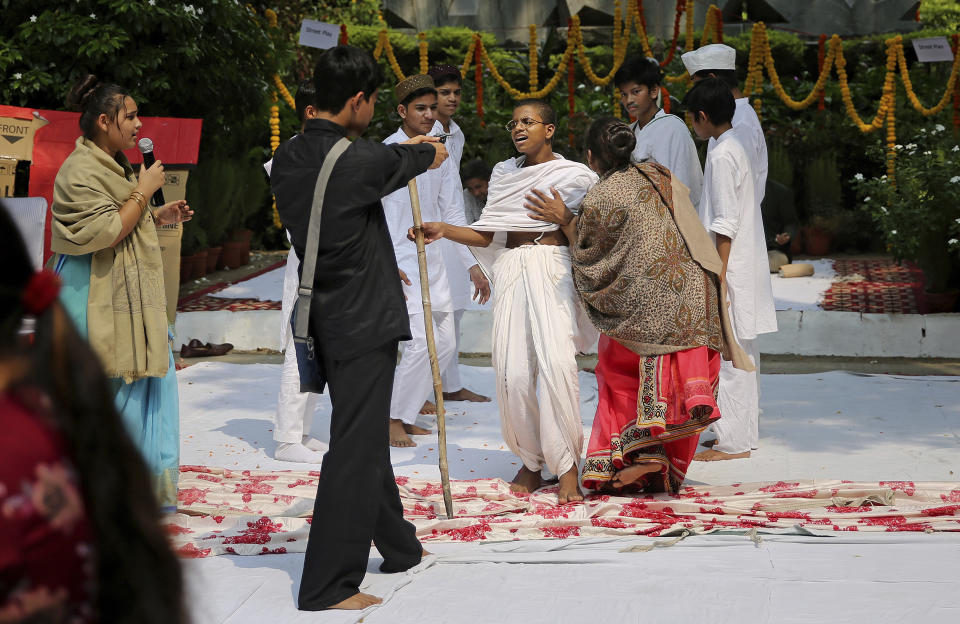 School children re-enact the assassination of India's independence leader Mahatma Gandhi during an event to celebrate his 150th birth anniversary in New Delhi, India, Tuesday, Oct. 1, 2019. India’s biggest political parties are vying for the political legacy of iconic independence leader Mahatma Gandhi on the 150th anniversary of his birth. (AP Photo/Altaf Qadri)