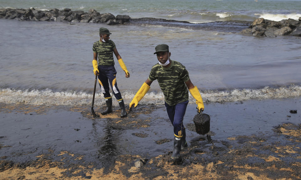 Sri Lankan army soldiers work to remove oil from a beach following an oil spill in Uswetakeiyawa, a coastal town north of Colombo, Sri Lanka, Monday, Sept. 10, 2019.Sri Lanka deployed hundreds of coast guard and navy personnel on Monday to clean oil slicks on a coastal stretch near the capital following a spill caused by a pipeline leak. (AP Photo/Eranga Jayawardena)