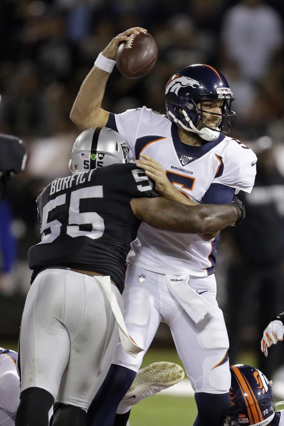 Denver Broncos quarterback Joe Flacco is tackled by Oakland Raiders outside linebacker Vontaze Burfict (55) during the first half of an NFL football game Monday, Sept. 9, 2019, in Oakland, Calif. (AP Photo/Ben Margot)