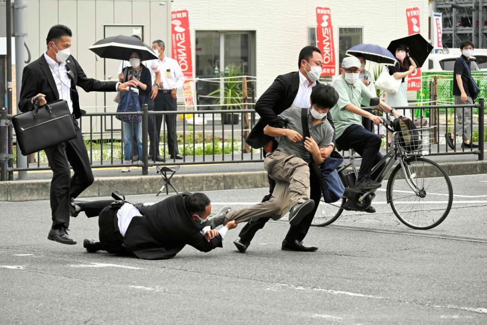 A man suspected of shooting former Japanese prime minister Shinzo Abe being tackled to the ground by police (Asahi Shimbun/AFP via Getty Images)