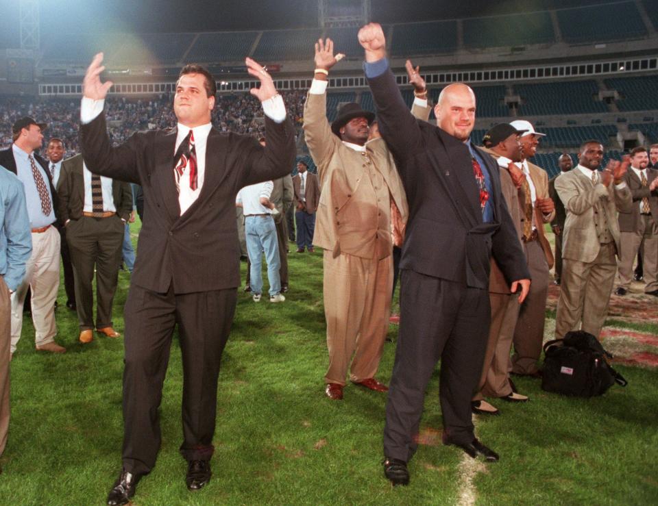 Jaguars players, from left, with hands raised, Brian DeMarco, Leon Searcy and Michael Cheever acknowledge the thousands of fans who came to Jacksonville Municipal Stadium at 1:30 a.m. Sunday to greet the team after beating the Denver Broncos 30-27 in the playoffs on Jan. 4, 1997.