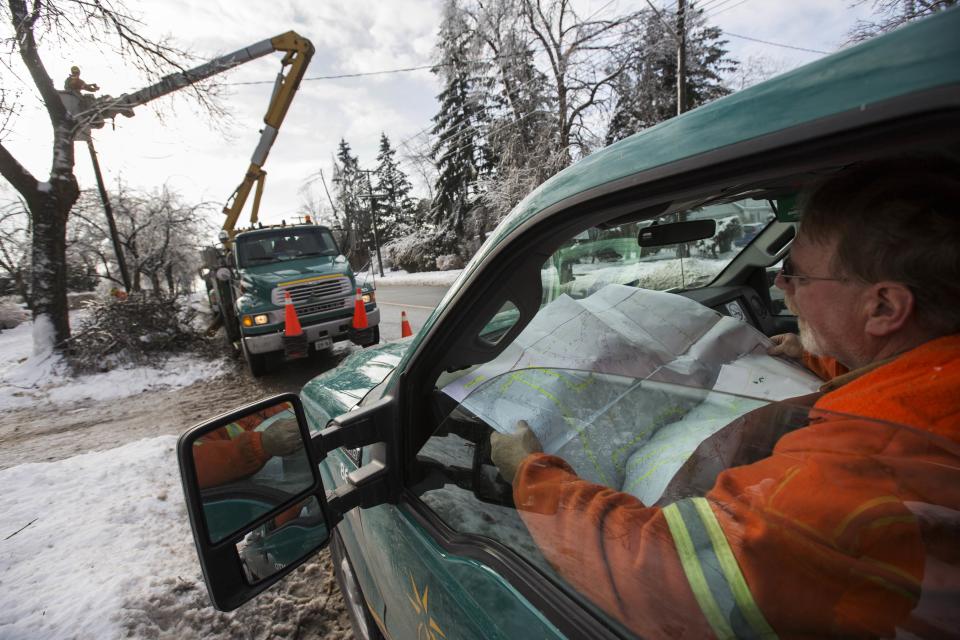 A Toronto Hydro worker looks at a map in the Scarborough suburb following an ice storm as others work to restore power in Toronto, December 27, 2013. Over 30,000 residents were left without power in Toronto Friday since the storm hit on December 22, local media reported. REUTERS/Mark Blinch (CANADA - Tags: ENVIRONMENT ENERGY)