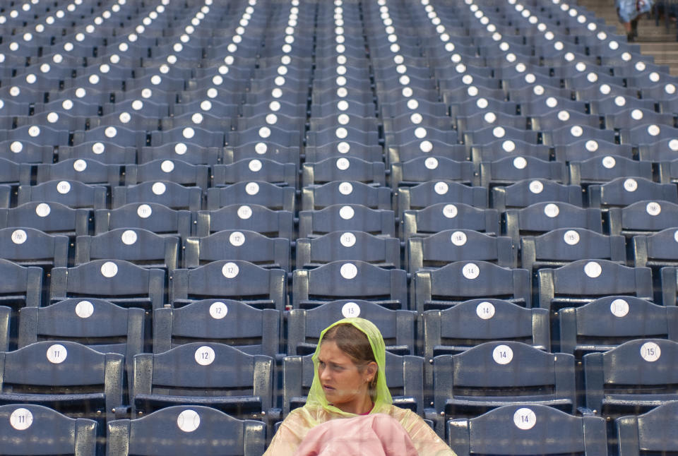 A fan waits out a rain delay after the second inning of a baseball game between the Philadelphia Phillies and the Washington Nationals, Sunday, Sept. 11, 2022, in Philadelphia. (AP Photo/Laurence Kesterson)