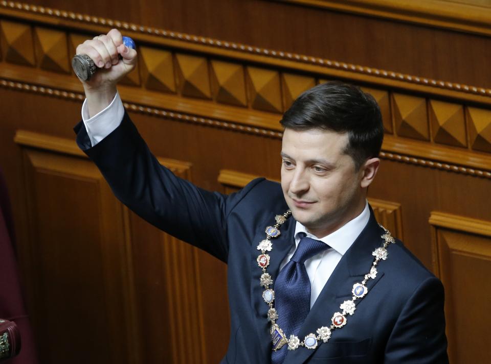 Ukrainian new President Volodymyr Zelenskiy holds the Ukrainian symbols of power during his inauguration ceremony in Kiev, Ukraine, Monday, May 20, 2019. Television star Volodymyr Zelenskiy has been sworn in as Ukraine's next president after he beat the incumbent at the polls last month. The ceremony was held at Ukrainian parliament in Kiev on Monday morning. (AP Photo/Efrem Lukatsky)