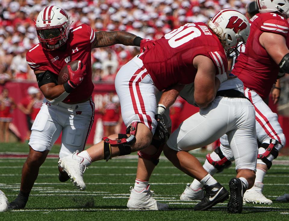 Wisconsin running back Chez Mellusi (1) takes advantage of a block by offensive lineman Joe Huber (60) during the first quarter of their game against Buffalo Saturday, Sept. 2, 2023, at Camp Randall Stadium in Madison, Wisconsin.