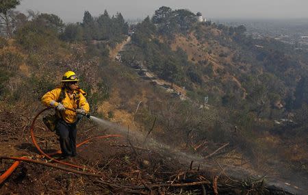 A firefighter works on a fire near the landmark Griffith Observatory in the hills overlooking Los Angeles, California, U.S. July 10, 2018.