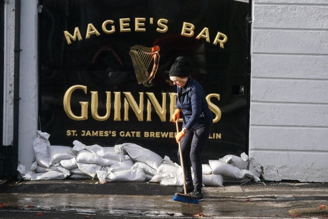 Delia Magee sweeps up outside Magee’s Bar, which has been in her husband’s family since 1913, as the clear up begins in Newry Town, Co Down, which has been swamped by floodwater as the city’s canal burst its banks amid heavy rainfall. 