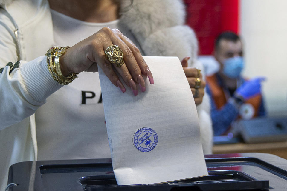 A woman casts her ballot during parliamentary elections in capital Tirana, Albania, Sunday, April 25, 2021. Albanians are voting in parliamentary elections amid the virus pandemic and a bitter political rivalry between the two largest political parties. (AP Photo/Visar Kryeziu)