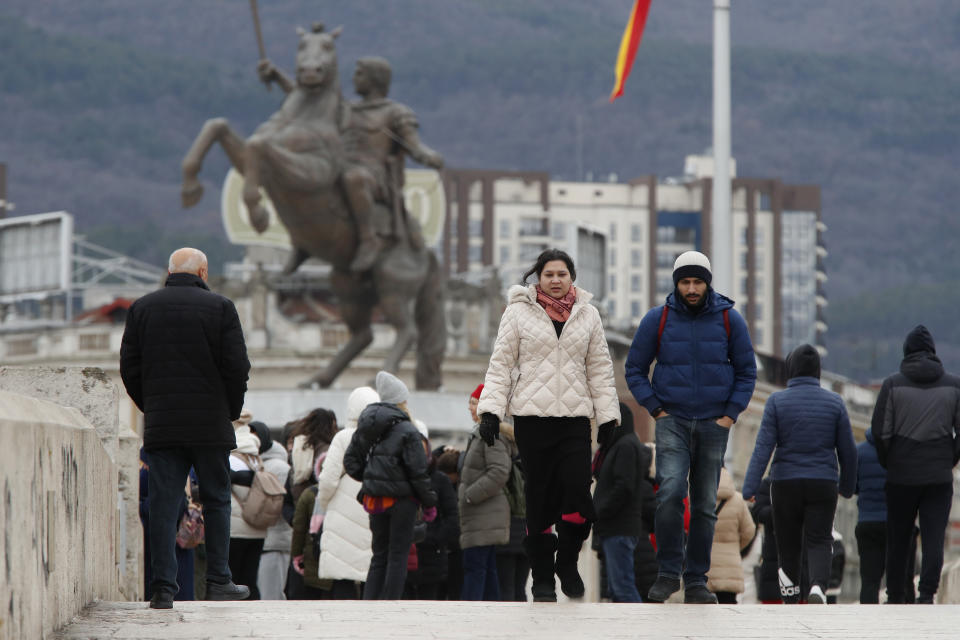 People walk through downtown Skopje, North Macedonia, on Sunday, Jan. 28, 2024. North Macedonia's parliament has approved on Sunday a new caretaker government installed ahead of general elections this May. (AP Photo/Boris Grdanoski)