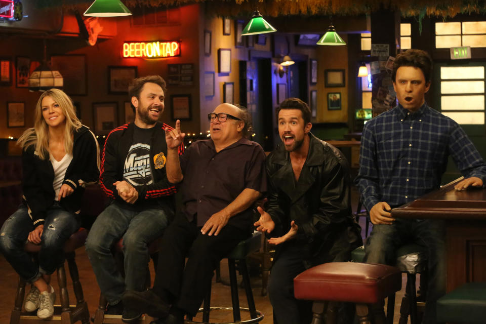 Kaitlin Olson, Charlie Day, Danny DeVito, Rob McElhenney, and a sex doll that looks like Glenn Howerton sit in Paddy's Pub